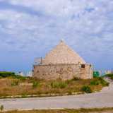A suggerirci la presenza del lido � un vero e proprio trullo che si fa spazio tra le sterpaglie di una grande aria incolta percorsa da un viottolo